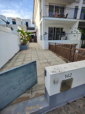 a building with a brick walkway next to a house at PORTO SANTO MyLove in Porto Santo