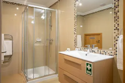 a bathroom with a shower and a sink and a mirror at Boavista Golf & Spa - Bela Colina Holidays in Lagos