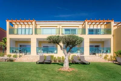 a building with chairs and a tree in the yard at Boavista Golf & Spa - Bela Colina Holidays in Lagos