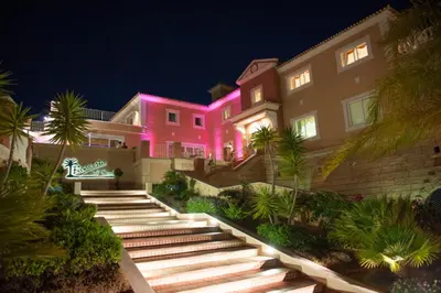 a pink building with stairs in front of it at night at Boavista Golf & Spa - Bela Colina Holidays in Lagos