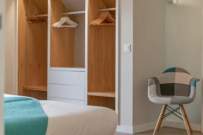 a bedroom with a bed and a chair at NEW! Villa Alvinho| Lifestyle&Nature | Heated Pool in Funchal