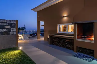 a patio of a house with a fireplace at NEW! Villa Alvinho| Lifestyle&Nature | Heated Pool in Funchal