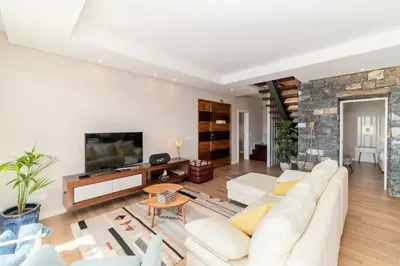 a living room with a white couch and a stone fireplace at NEW! Villa Alvinho| Lifestyle&Nature | Heated Pool in Funchal