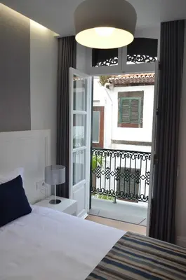 a bedroom with a bed and a door to a balcony at Edificio Charles 204 in Funchal