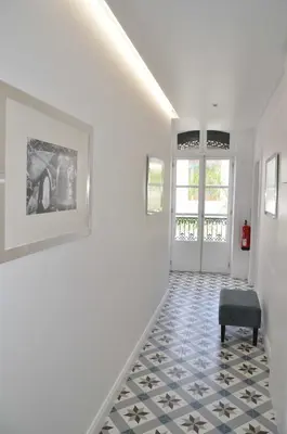 a hallway with white walls and a blue and white tile floor at Edificio Charles 204 in Funchal