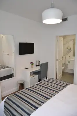 a bedroom with a bed and a desk and a television at Edificio Charles 204 in Funchal