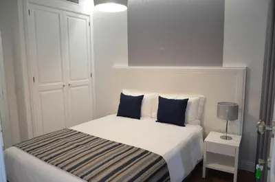 a bedroom with a white bed with blue pillows at Edificio Charles 204 in Funchal