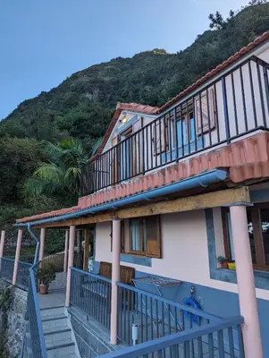 a house with stairs and a mountain in the background at Fantatic Holiday House in Ponta Delgada