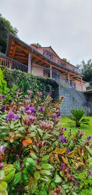 a garden with purple flowers in front of a house at Fantatic Holiday House in Ponta Delgada