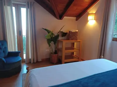 a bedroom with a bed and a blue chair at Fantatic Holiday House in Ponta Delgada