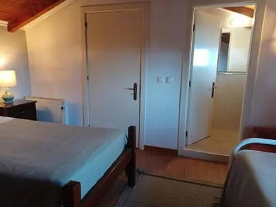a bedroom with a bed and a glass door with a shower at Fantatic Holiday House in Ponta Delgada