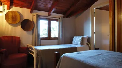 a bedroom with a bed and a chair and a window at Fantatic Holiday House in Ponta Delgada