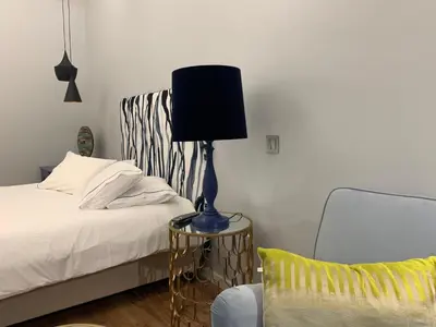 a bed with a lamp on a table next to a chair at Central - São Pedro Boutique in Funchal