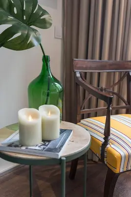 a table with two candles and a vase and a chair at Central - São Pedro Boutique in Funchal