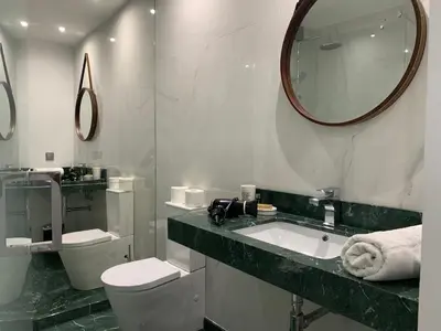a bathroom with a sink and a toilet and a mirror at Central - São Pedro Boutique in Funchal