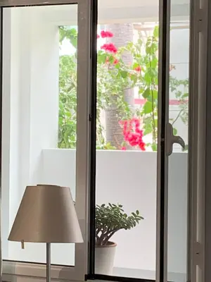 a room with a lamp and a window with flowers at Central - São Pedro Boutique in Funchal