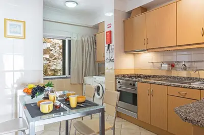 a kitchen with a table with fruit on it at Reis Magos II by An Island Apart in Caniço