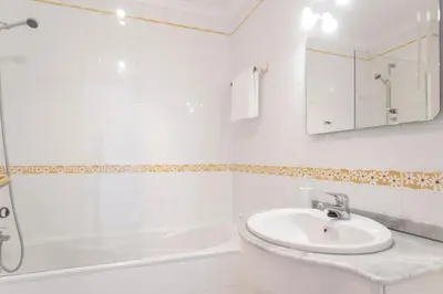 a white bathroom with a sink and a shower at Reis Magos II by An Island Apart in Caniço