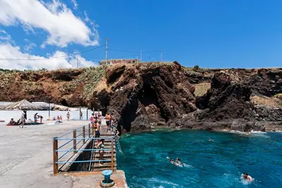 a group of people in the water at a beach at Reis Magos II by An Island Apart in Caniço