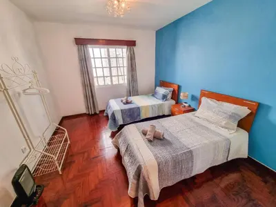two beds in a room with blue walls and wooden floors at Casa da Achada in Arco da Calheta in Arco da Calheta