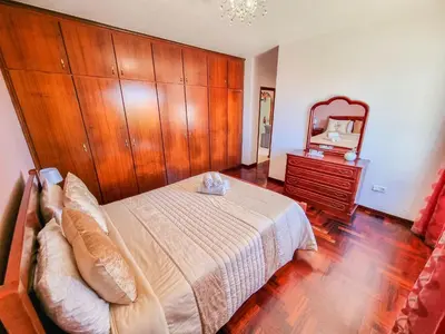 a bedroom with a large bed and a mirror at Casa da Achada in Arco da Calheta in Arco da Calheta