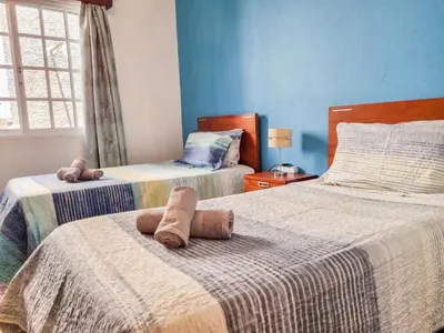 two beds in a bedroom with blue walls at Casa da Achada in Arco da Calheta in Arco da Calheta
