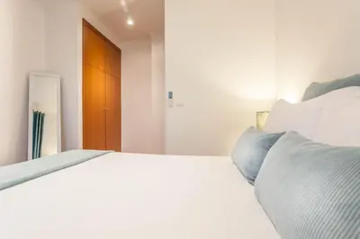 a bedroom with a bed with white sheets and blue pillows at Blue Sky in Funchal