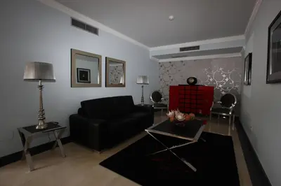 a living room with a black couch and a red chair at Hotel Apartamentos Baia Brava in Gaula