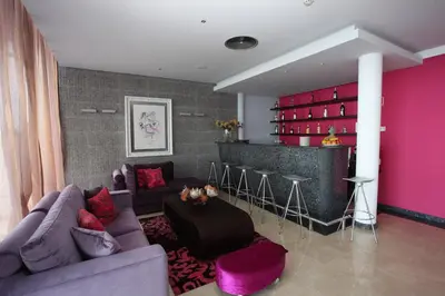 a living room with a purple couch and a bar at Hotel Apartamentos Baia Brava in Gaula