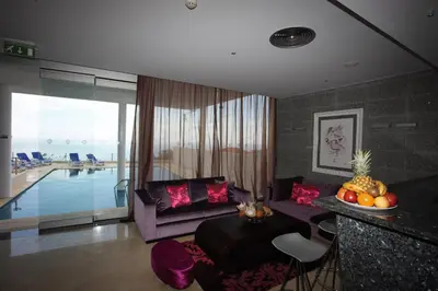a living room with a couch and a pool at Hotel Apartamentos Baia Brava in Gaula