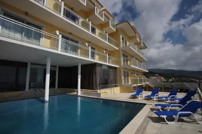 a hotel swimming pool with chairs and a building at Hotel Apartamentos Baia Brava in Gaula