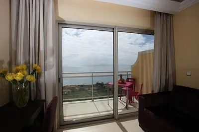 a living room with a large glass door to a balcony at Hotel Apartamentos Baia Brava in Gaula