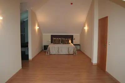a bedroom with a bed and a wooden floor at Hotel Apartamentos Baia Brava in Gaula