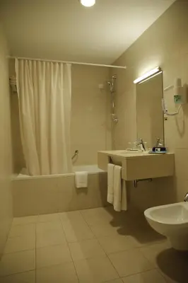 a bathroom with a tub and a sink and a shower at Hotel Mira Sagres in Vila do Bispo