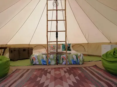 a bed in a tent with a ladder at Granny's farm in São Vicente
