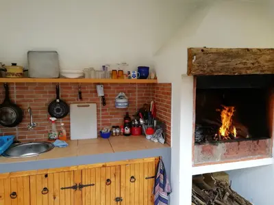 a kitchen with a fireplace and a stove at Granny's farm in São Vicente
