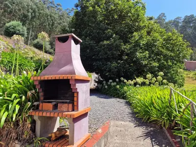 a small brick oven sitting in a garden at Cantinho Rural in Camacha