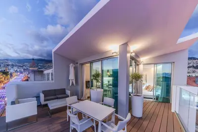 a living room with a balcony with a table and chairs at FAA Rentals 31 de Janeiro by An Island Apart in Funchal