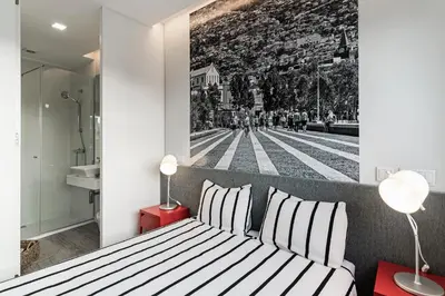 a bedroom with a black and white photo on the wall at FAA Rentals 31 de Janeiro by An Island Apart in Funchal