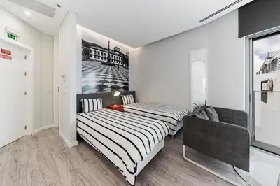 a bedroom with two beds and a couch at FAA Rentals 31 de Janeiro by An Island Apart in Funchal