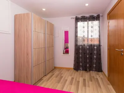 a bedroom with a bed and a dresser and a window at Casa Silva in Calheta