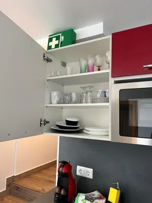 a kitchen with white shelves and a microwave at Casa Silva in Calheta