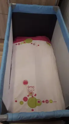 a baby crib with a bedsheet with aeddy bear on it at Casa Silva in Calheta
