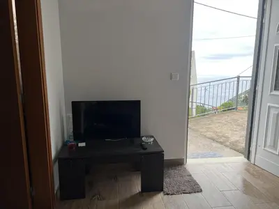 a living room with a tv and a table with a television at Casa Silva in Calheta