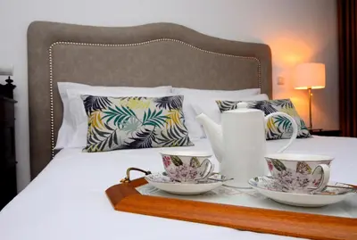 a tray with two tea cups on a bed at Casas do Forte do Pico in Funchal