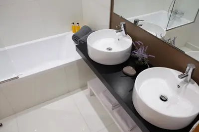 a white bathroom with a sink and a bath tub at Casas do Forte do Pico in Funchal