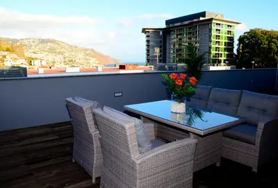 a balcony with a table and chairs and a building at Casas do Forte do Pico in Funchal