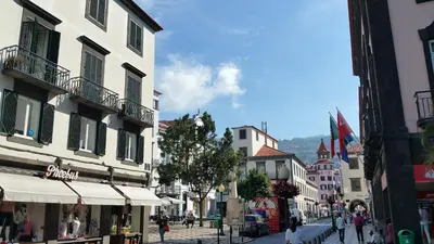 a city street with buildings and people walking down a street at Edificio Charles 301 in Funchal