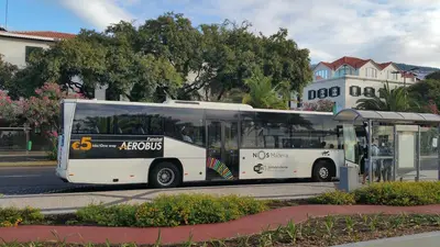 a white bus parked at a bus stop at Edificio Charles 301 in Funchal