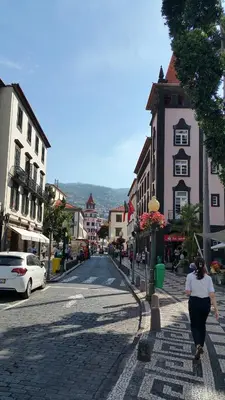a woman walking down a street in a town at Edificio Charles 301 in Funchal